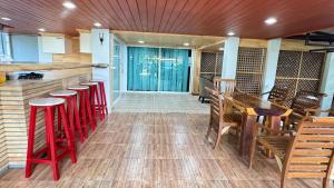 een kamer met een bar met rode krukken bij พิมพ์วนา เขาใหญ่ in Nakhon Ratchasima