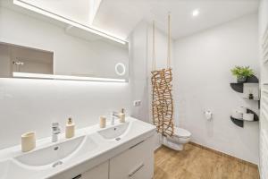 a white bathroom with a sink and a toilet at dreamfactory Residence - Eastside in Vienna