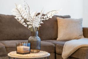 a vase with a candle on a table with a couch at dreamfactory Residence - Eastside in Vienna +4 photos