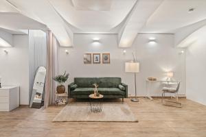 a living room with a green couch and a table at dreamfactory Residence - Eastside in Vienna