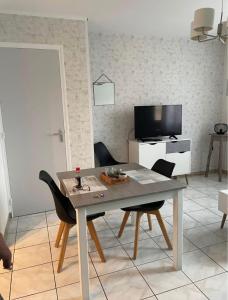 een eettafel en stoelen in de woonkamer bij Appartement Troyes in Troyes