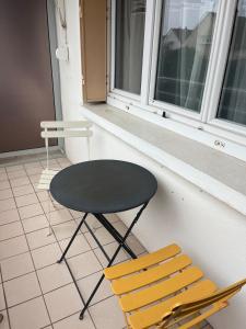 een tafel en twee stoelen naast een raam bij Appartement Troyes in Troyes +5 foto's