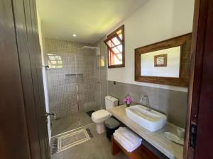 ein Badezimmer mit Waschbecken, Toilette und Dusche in der Unterkunft Pousada Sete Quedas in Carrancas