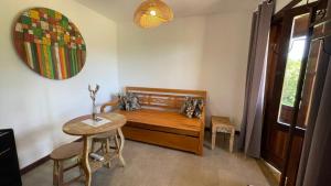 ein Zimmer mit einem Holzbett, einem Tisch und einem Spiegel in der Unterkunft Pousada Sete Quedas in Carrancas