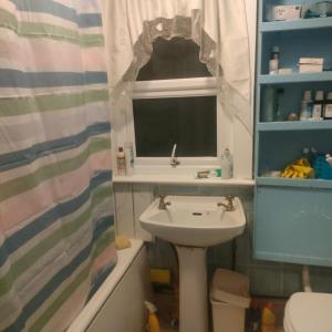 a bathroom with a sink and a window at Room2let in Moffat
