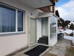 an open glass door of a house with a porch at Tamara Parterre in Riederalp