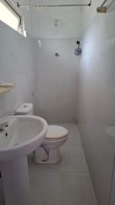 a white bathroom with a toilet and a sink at Priya Villa Homestay in Jaffna +11 photos