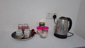 a counter top with a coffee maker and several cups at Priya Villa Homestay in Jaffna