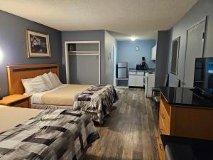 a hotel room with two beds and a flat screen tv at Metro Inn in Victoria