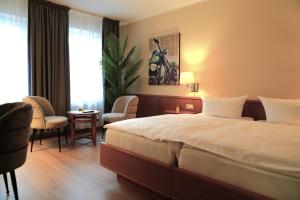 a hotel room with a bed and a table and chairs at Hotel Bentheimer Eck in Bad Bentheim
