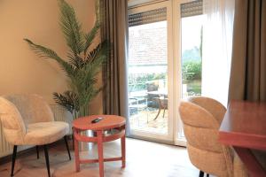 a room with chairs and a table and a window at Hotel Bentheimer Eck in Bad Bentheim