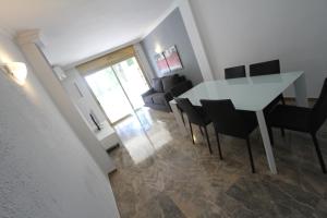 a dining room with a white table and chairs at For A Stay Cala Dorada in Salou