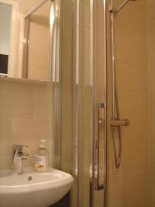 a shower with a glass door next to a sink at Eiffel Tower studio with patio in Paris