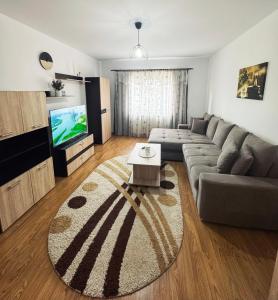 un soggiorno con un divano e una TV di Edge Apartament a Cristuru Secuiesc