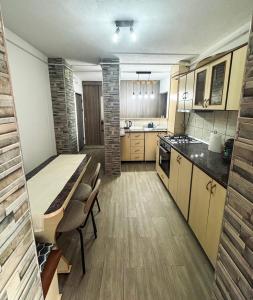 una grande cucina con tavolo e sedie di Edge Apartament a Cristuru Secuiesc