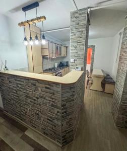 una cucina con parete in mattoni e isola cucina di Edge Apartament a Cristuru Secuiesc Altre 2 foto