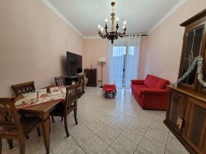 een woonkamer met een tafel en een rode bank bij Appartamento Galileo Ferraris, in Vercelli