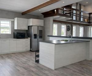 a kitchen with white cabinets and a counter top at Maison Meredith in Paramaribo