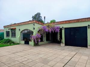 a house with purple wisteria on the side of it at La Casita Junin in Junín