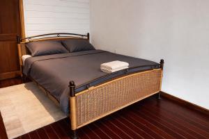 ein Bett mit einem Korbgeflechtrahmen in einem Zimmer in der Unterkunft Maison Meredith in Paramaribo