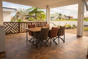 a dining room with a table and chairs on a patio at Maison Meredith in Paramaribo