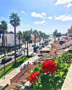 カスカイスにあるCascais Terrace Bay Apartmentのヤシの木や赤い花が咲く通りの景色