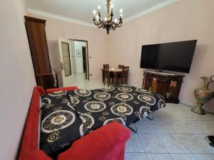 een woonkamer met een tafel, een bank en een televisie bij Appartamento Galileo Ferraris, in Vercelli +25 foto's