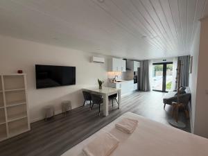 a living room with a table and a kitchen at Vila Pombal Tomar Apartments - Pool & City Views in Tomar