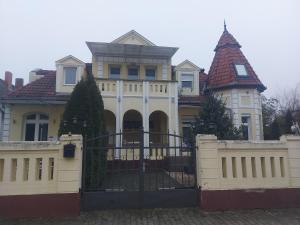 a large house with a gate in front of it at Siófok 7 Apartmanház in Siófok