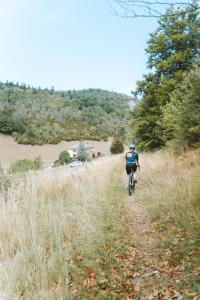 eine Person, die auf einem unbefestigten Weg Fahrrad fährt in der Unterkunft Hostel Quartier Libre in Saint-Jean-en-Royans
