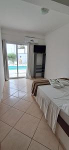 een slaapkamer met een bed en een tegelvloer bij Pousada Mar Alto in Ilha Comprida +40 foto's