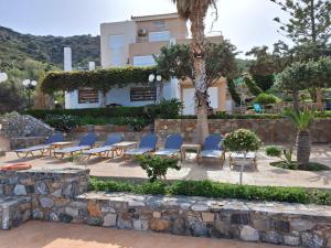 een patio met stoelen en een gebouw op de achtergrond bij Agnanti Villas in Agia Pelagia