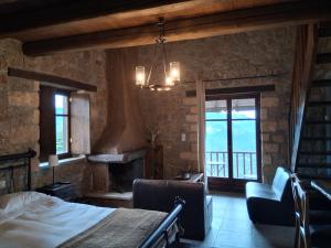 ein Schlafzimmer mit einem Bett und einem Stuhl und einem Kamin in der Unterkunft Ξενώνας Αστερωδή in Karya