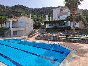 een groot zwembad voor een gebouw bij Agnanti Villas in Agia Pelagia