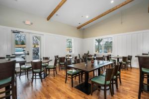 a dining room with tables and chairs and windows at Carolina Camp Cedar in Pickens