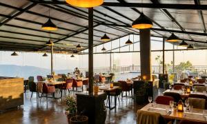 een restaurant met tafels, stoelen en verlichting bij Hotel Chail Residency in Chail