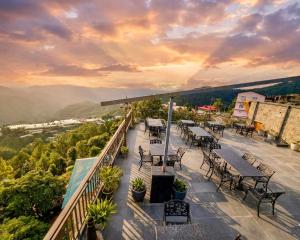 een patio met tafels en stoelen op een balkon bij Hotel Chail Residency in Chail
