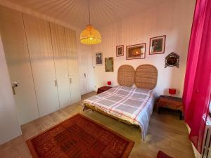 een slaapkamer met een bed en een kroonluchter bij Il Gelsomino "Meraviglioso appartamento in villa Liberty" in Gorizia