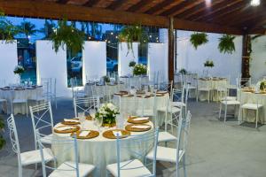 a group of tables with white chairs and tablesearcher at Pousada Espaço Vista Mar in Itanhaém