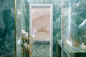 un bagno con un muro in pietra e una porta che conduce a una camera da letto di Stella Marina a Molfetta Altre 10 foto