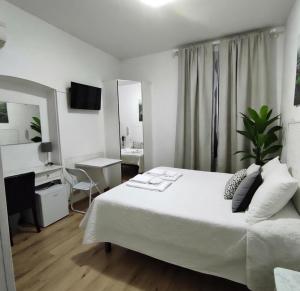 a bedroom with a large white bed and a desk at Hotel Birillo in La Spezia +35 photos