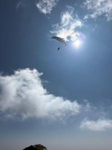 a kite is flying in a cloudy sky at Thatharana Trek by Mountain Hikers - Mudhouse & Cafe in Dharmsāla