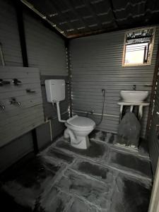 a dirty bathroom with a toilet and a sink at Thatharana Trek by Mountain Hikers - Mudhouse & Cafe in Dharmsāla +277 photos
