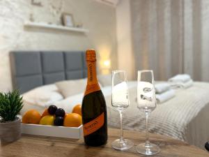a bottle of wine and two glasses on a table at Apartmány ZELENÝ DOM in Podhájska