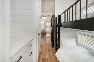 a white bedroom with a bed and a staircase at Carolina Camp Cedar in Pickens +56 photos