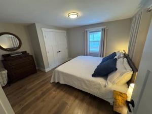 een slaapkamer met een bed, een ladekast en een spiegel bij Sebago Basin Getaway - An Unforgettable Experience in North Windham +14 foto's
