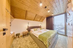 een slaapkamer met een groot bed en een groot raam bij Rezidence Za Vodou - Čáp in Cerny Dul