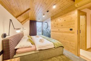 een slaapkamer met een bed en een houten wand bij Rezidence Za Vodou - Čáp in Cerny Dul