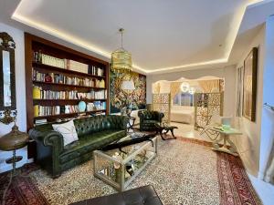 ein Wohnzimmer mit einem grünen Sofa und Bücherregalen in der Unterkunft Le Chesterfield Gammarth in Gammarth