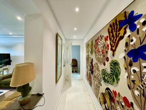 einen Flur mit einem großen Gemälde an der Wand in der Unterkunft Le Chesterfield Gammarth in Gammarth + 21 Fotos